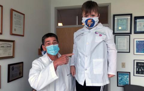 Dr. Marc Rothenberg, MD, PhD poses with a CEGIR patient who wears a mask that reads, "Hero"